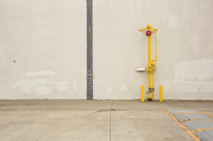 Minimal urban landscape photograph of architecture with a yellow pipe against a wall