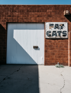 Minimal urban landscape photograph of architecture with a Fat Cats sign